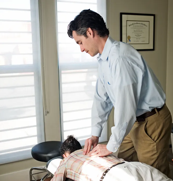 Dr. Matthew Gloin performing a chiropractic adjustment on a patient at Live Well Chiropractic and Pilates Center